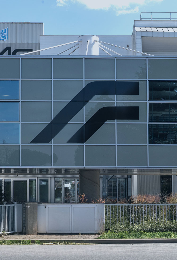 Façade vitrée du siège FAAC avec le logo de l'entreprise, vue depuis la rue