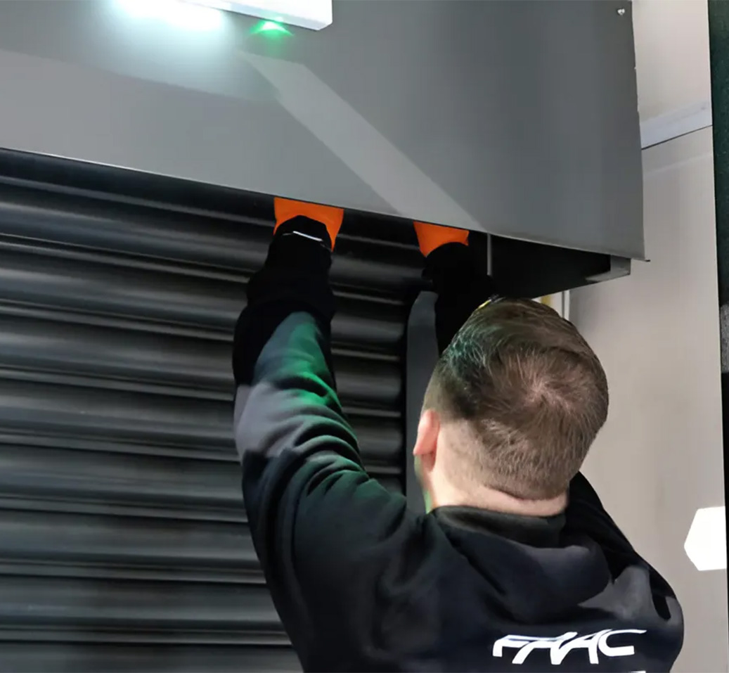Technicien FAAC remplaçant la motorisation d'une porte automatique avec le kit de modernisation RKU
